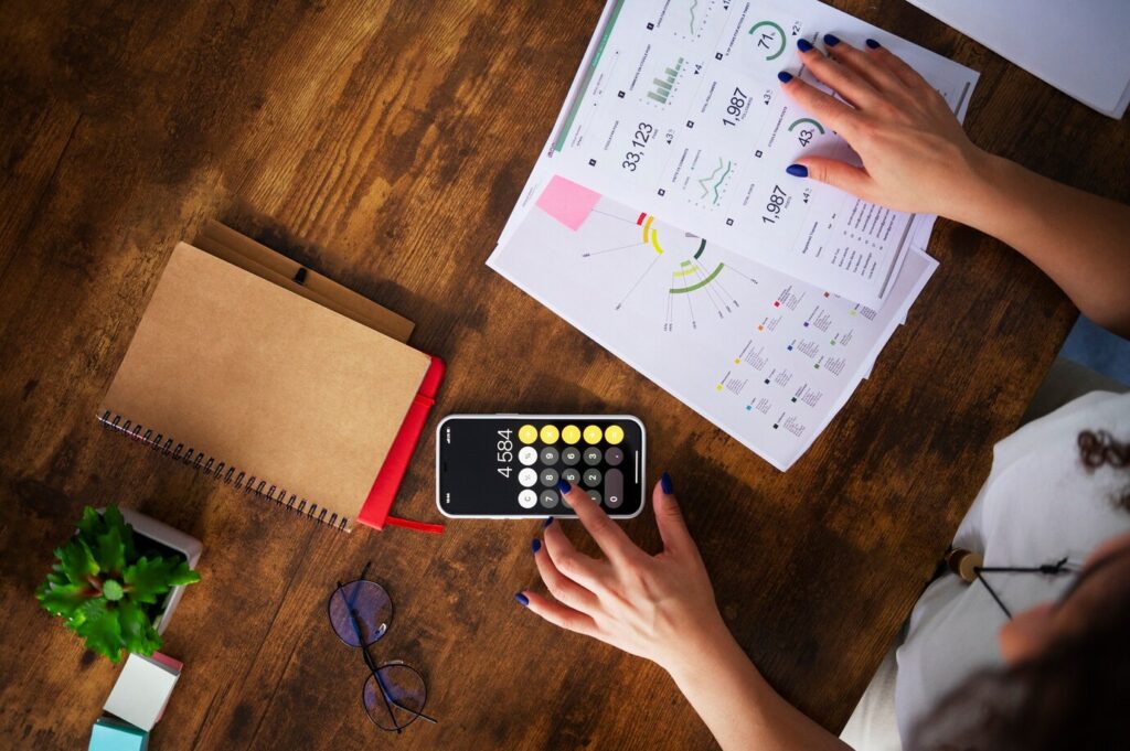 person using a calculator on their phone