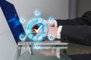 person in a suit uses a laptop, surrounded by glowing icons